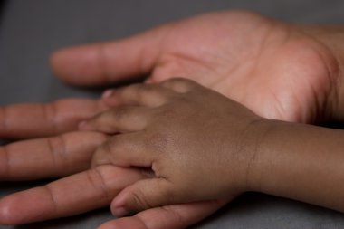 Hand of a baby in his mother's hand clipart