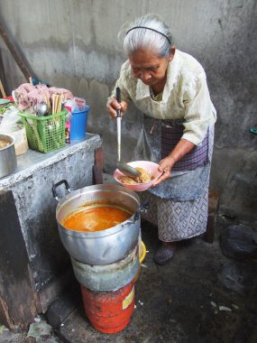 Bangkok October 2010.The old woman drew a plate of food to customers at market , Bangkok thailand clipart