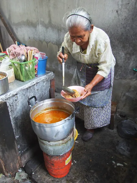 Stock image Bangkok October 2010.The old woman drew a plate of food to customers at market , Bangkok thailand