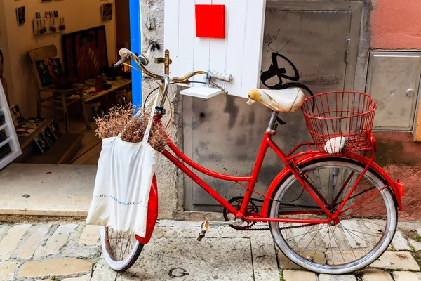 Bicicleta vermelha velha na porta da loja em Rovinj, Croácia — Fotografia de Stock