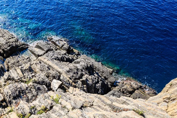 Modré mořské hladině a skály poblíž manarola v cinque terre, Itálie — Stock fotografie
