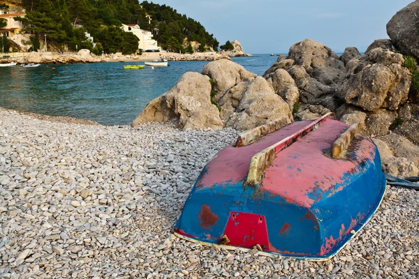 Łódź na kamienistej plaży w Chorwacji do góry nogami — Zdjęcie stockowe