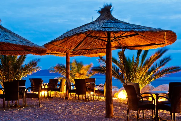 在晚上，brela，克罗地亚卵石海滩上的遮阳伞 — 图库照片