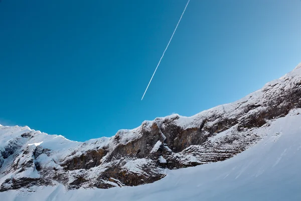 Airplane Trail in Blue Sky above Mountain Peak, French Alps — Stock Photo, Image