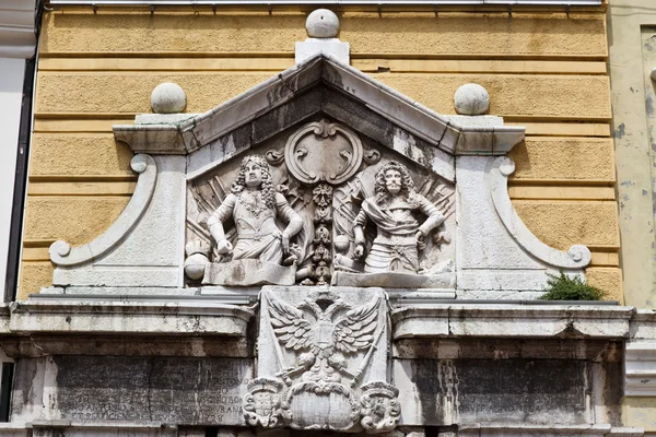 Reliéf s dvěma muži na žluté budově v rijeka, Chorvatsko — Stock fotografie
