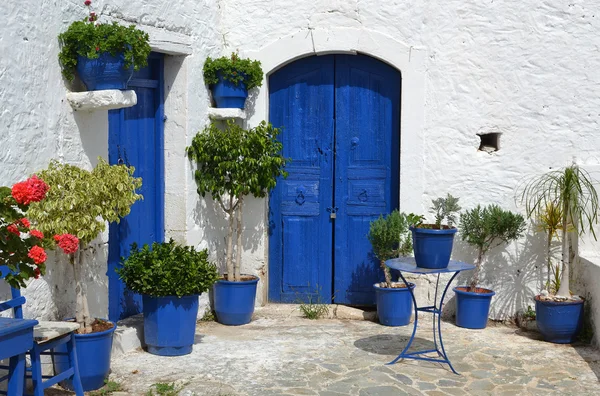 Typische Griekse binnenplaats met blauwe bloempotten. — Stockfoto