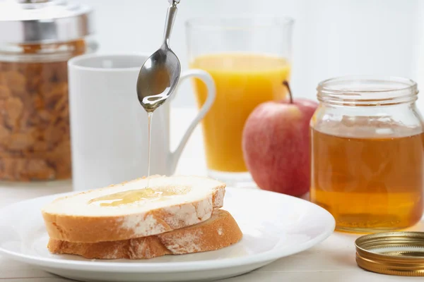 stock image Pouring honey on sliced bread