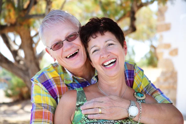 Glad äldre par leende och omfattar — Stockfoto