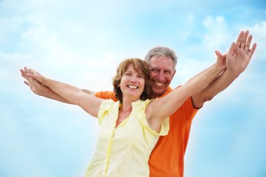 Mature couple with arms outstretched clipart