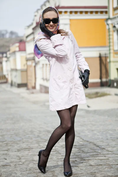 Menina em um lenço de cabeça e óculos escuros na cidade Fotos De Bancos De Imagens