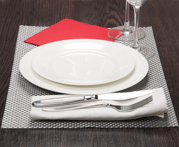 stock image Knife, white plate and fork on silver background