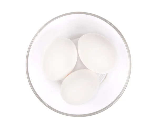 Three white eggs in a glass plate — Stock Photo, Image