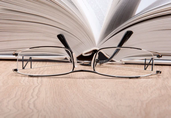 stock image Open book with glasses