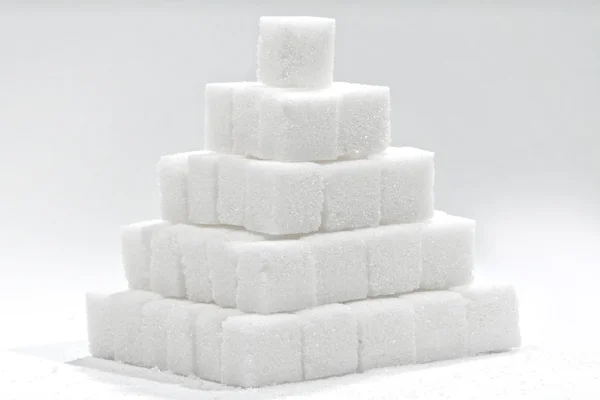Stack of white sugar cubes - sweet pyramid — Stock Photo, Image