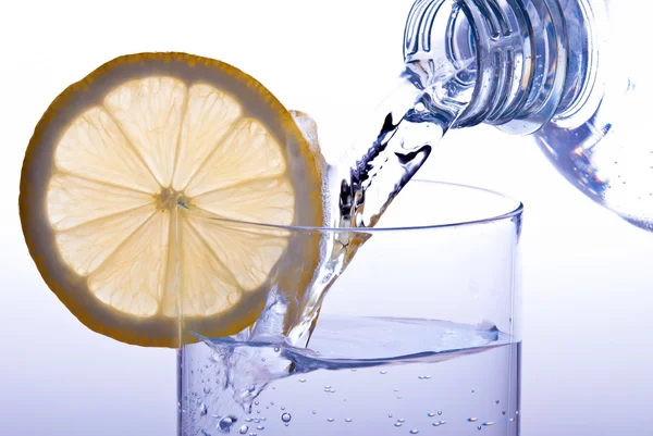 Pour glass of water with lemon — Stock Photo, Image