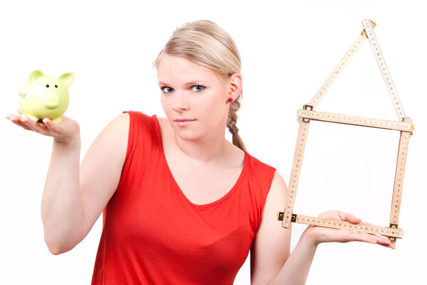 Young woman with house symbol and piggy bank