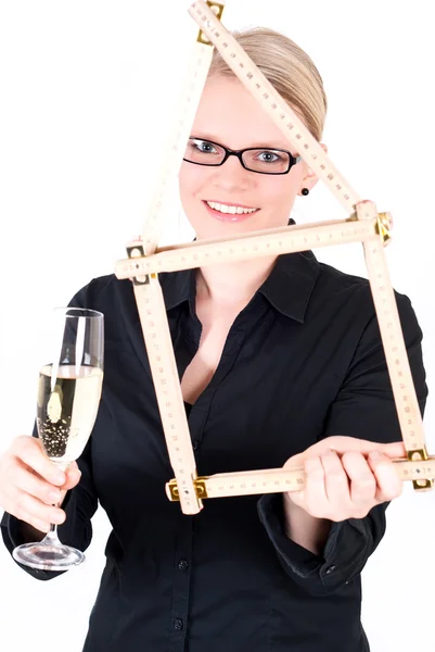 Młoda kobieta z domu symbol i szampan szkło — Zdjęcie stockowe