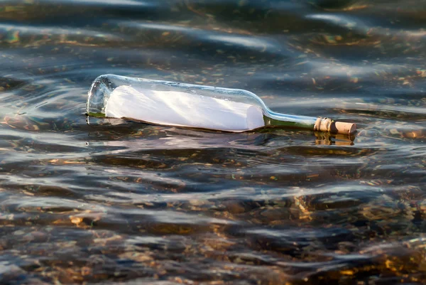 Послання у пляшці у воді — стокове фото
