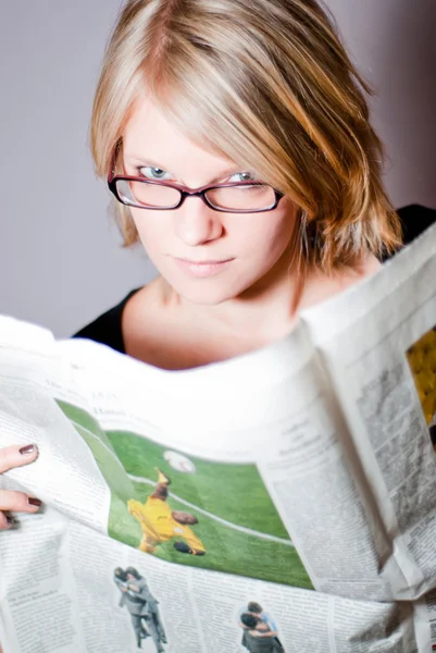 Молодая женщина в очках читает газету V1 — стоковое фото