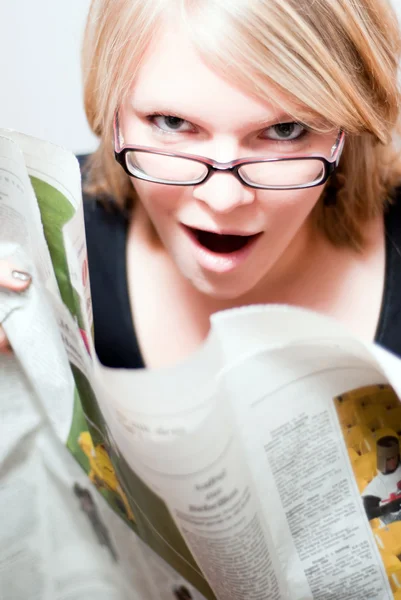 Молодая женщина в очках читает газету V3 — стоковое фото