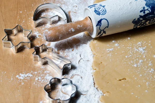 Rolling pin with flour and baking dishes in dough — Stock Photo, Image