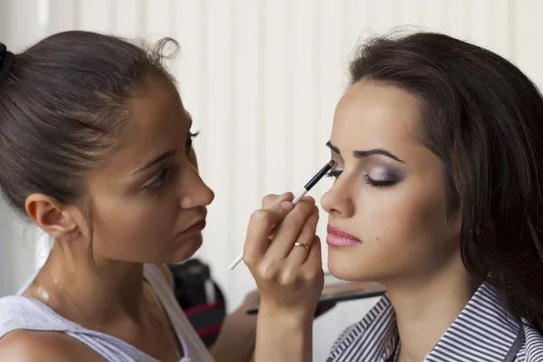 Make-up artiest schildert een model — Stockfoto