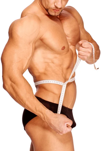 Se están midiendo las partes musculares y bronceadas del cuerpo masculino —  Fotos de Stock