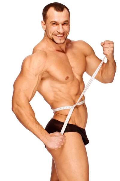 Se están midiendo las partes musculares y bronceadas del cuerpo masculino —  Fotos de Stock