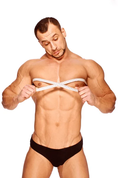 Partes do corpo masculino musculoso e bronzeado está sendo medido — Fotografia de Stock