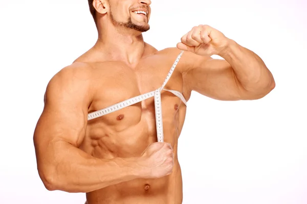 Les parties musculaires et bronzées du corps masculin sont mesurées — Photo