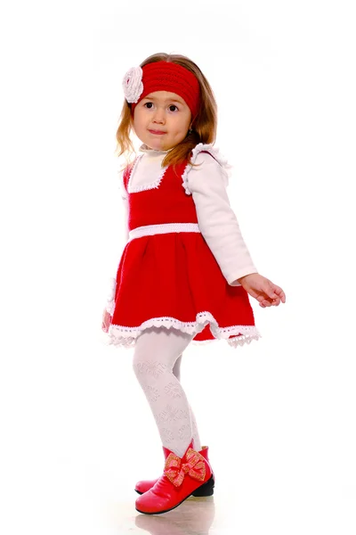 Een klein meisje in een gebreide jurk op een witte achtergrond — Stockfoto
