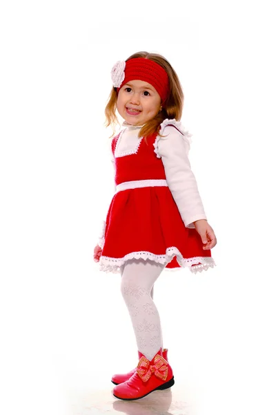 Ένα μικρό κορίτσι σε ένα πλεκτό φόρεμα σε λευκό φόντο — Φωτογραφία Αρχείου