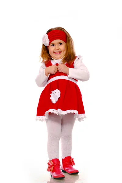 En liten flicka i en stickad klänning på en vit bakgrund — Stockfoto