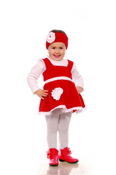 Ein kleines Mädchen in einem Strickkleid auf weißem Hintergrund — Stockfoto