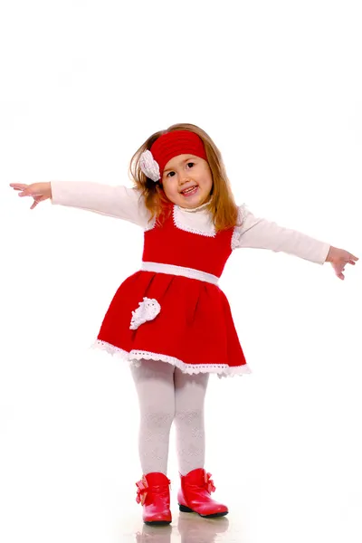 Una bambina in abito a maglia su sfondo bianco Foto Stock