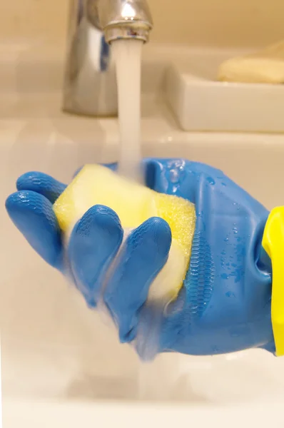 Stock image Hand wearing a working glove and a sponge