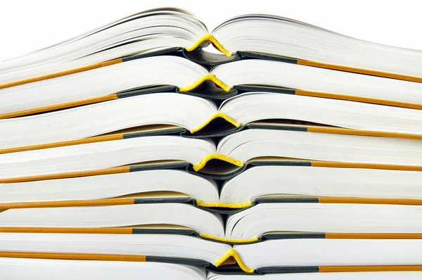 Pilha de livros abertos em close-up sobre fundo branco — Fotografia de Stock