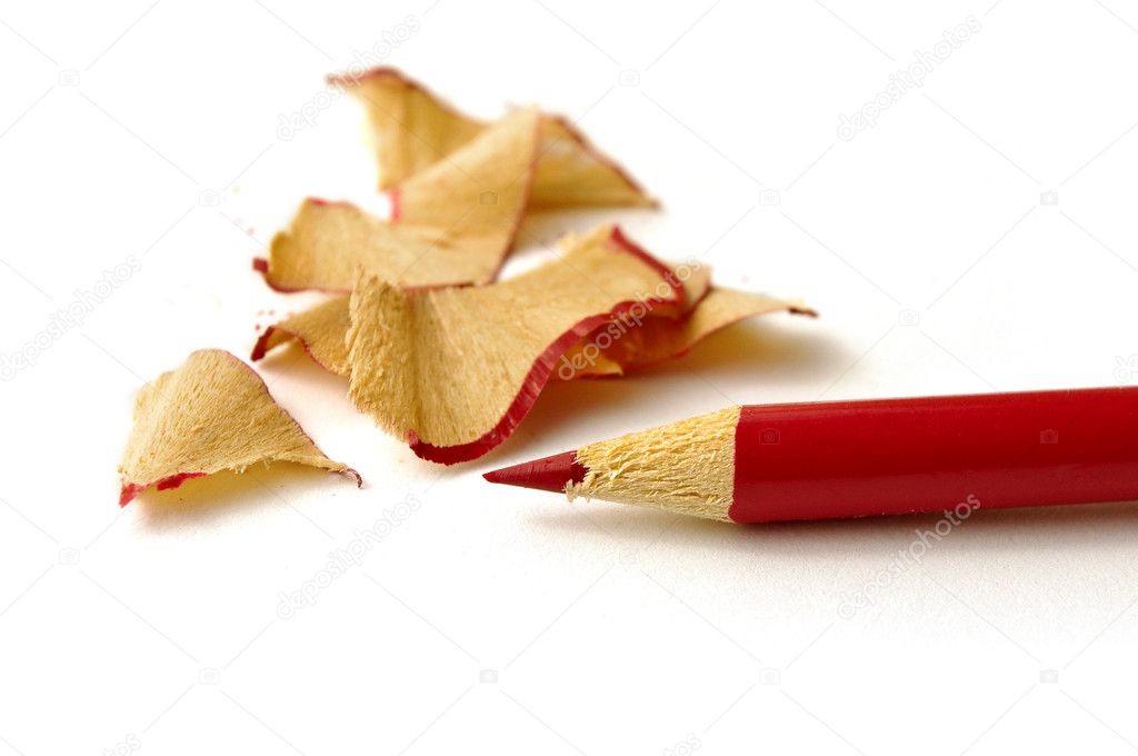 Red pencil and wood waste on white background