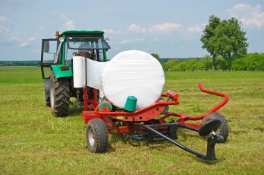 Way of gathering of hay in rolls clipart