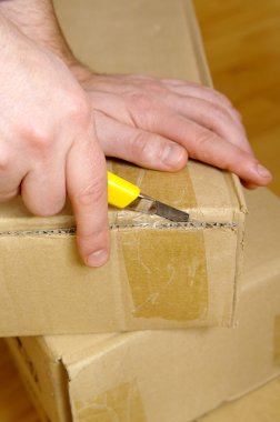 Man unpacking box with cutter clipart