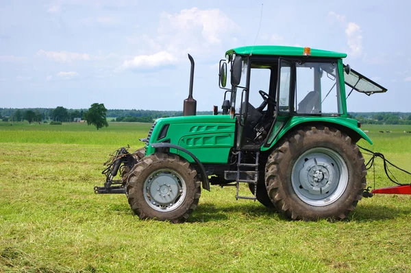 Green tractor in green field — Stock Photo, Image