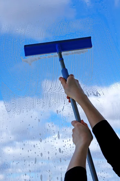Hand met zuigmond schoonmaken het beneveld venster — Stockfoto