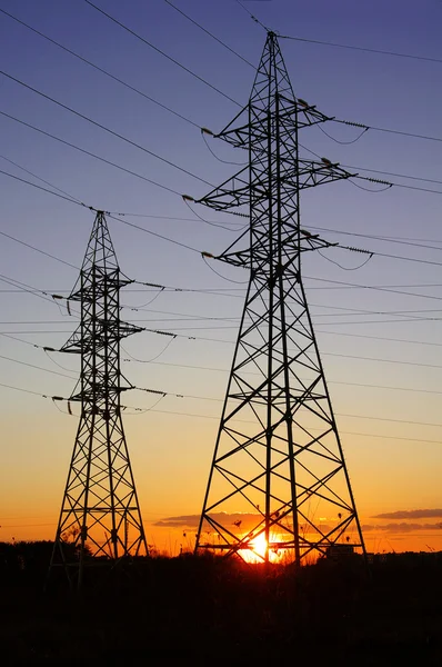 Eletricidade Pylon sobre laranja céu por do sol — Fotografia de Stock
