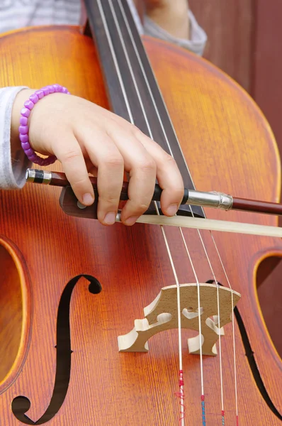 Nahaufnahme eines Cello und einer Mädchenhand — Stockfoto