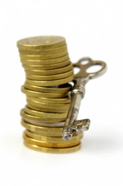 Pile of coins and key — Stock Photo, Image