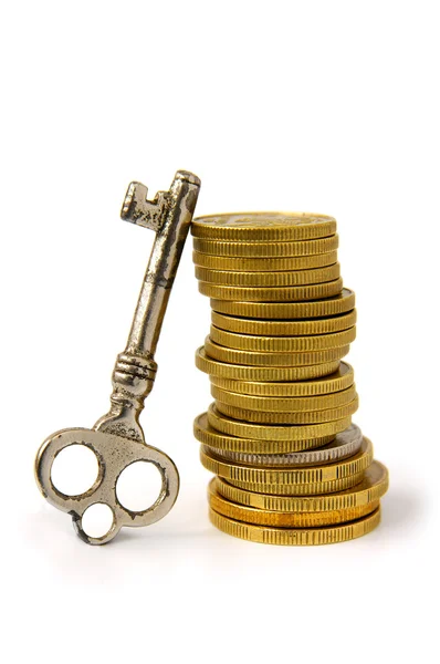 Pilha de moedas e chave — Fotografia de Stock