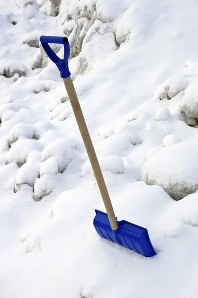 La pala azul plástica sobre la nieve —  Fotos de Stock