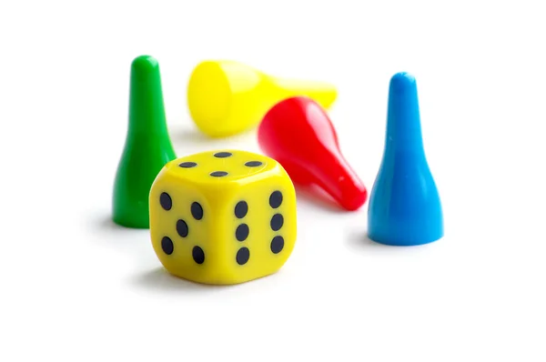 stock image Pawns in green, yellow, red and blue with a cube