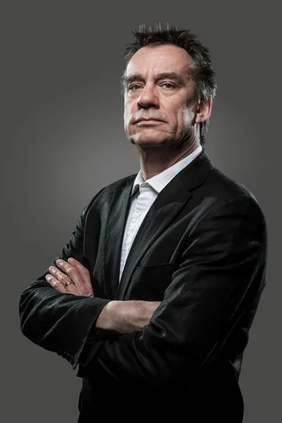 stock image Stern Imposing Business Man with Arms Folded on Grey Background