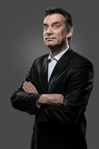 Geschäftsmann im Anzug zieht Gesicht auf grauem Grunge-Look lizenzfreie Stockfotos